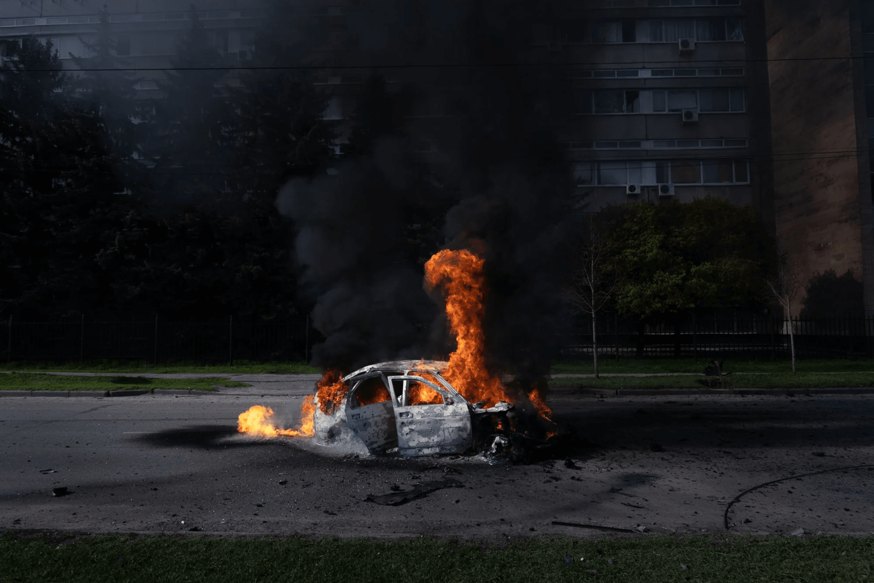 A car burns with two people inside after a Russian strike. Kharkiv, Ukraine. April 2022.