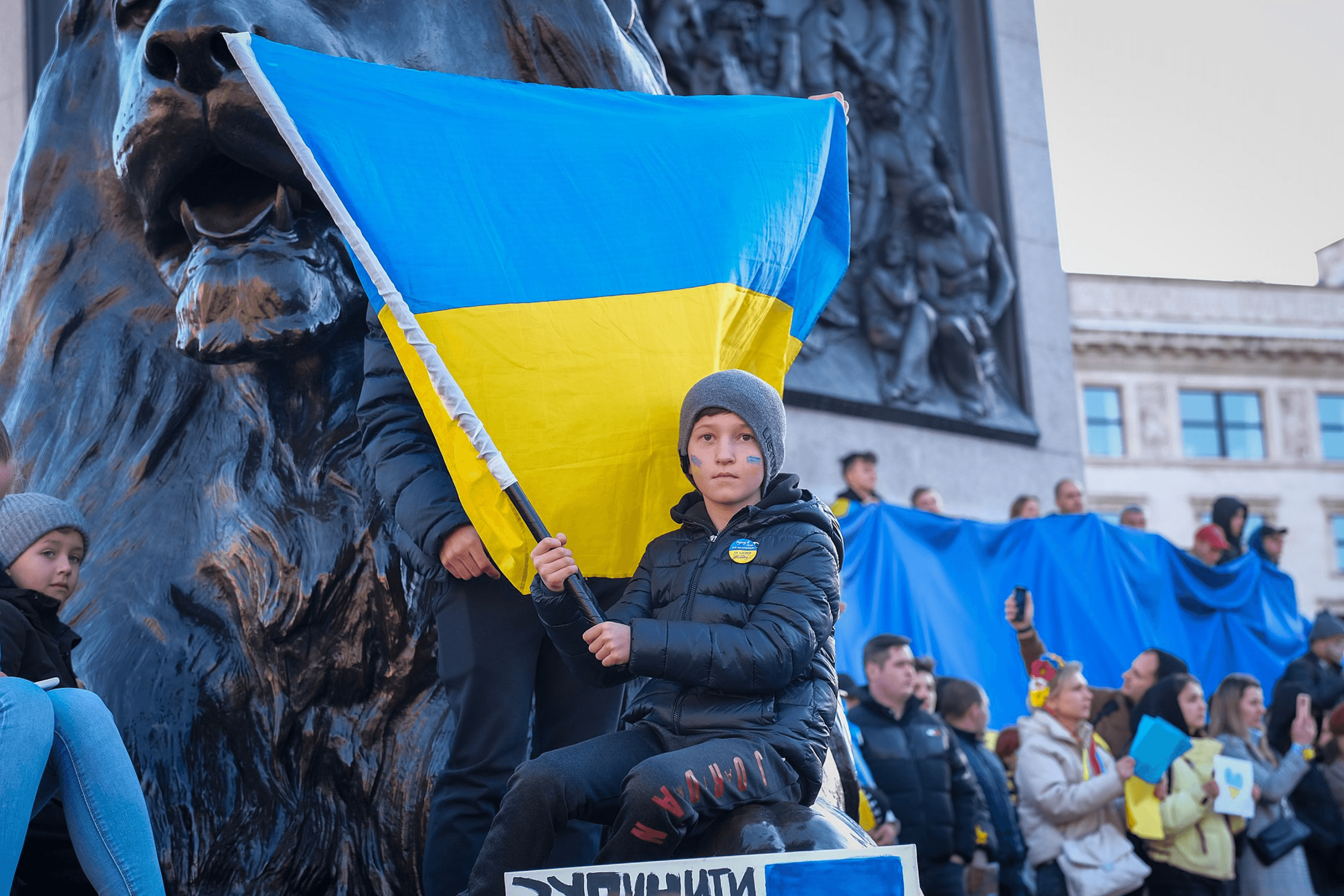 A child holding a Ukrainian flag during a pro-Ukraine rally at Trafalgar Square in London, United Kingdom. 2022.