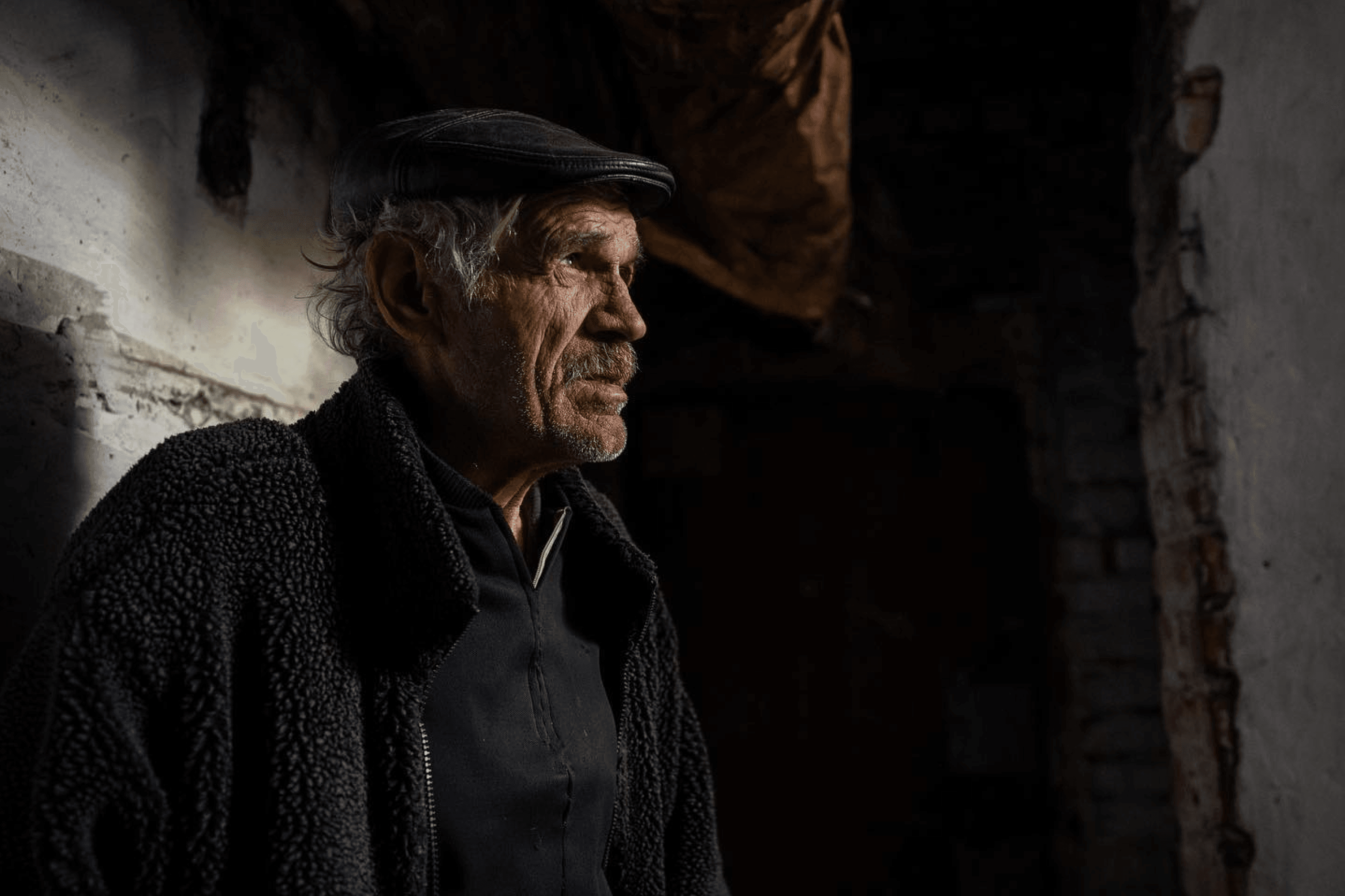 A man stands at the entrance of a basement used as a bomb shelter during Russian shelling, in a village near Kharkiv recently liberated by Ukrainian forces. Ukraine. April 2022.