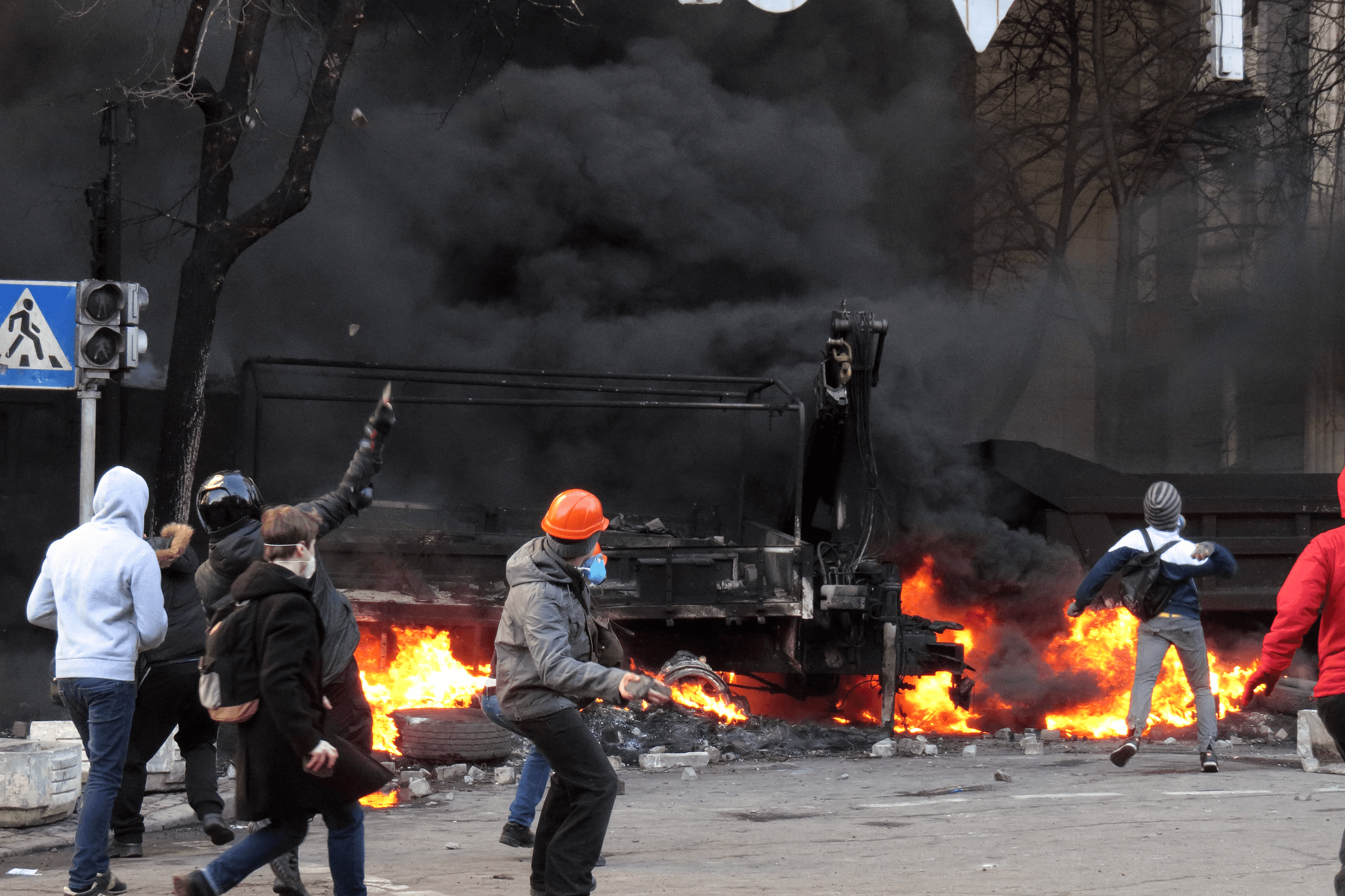 Protesters throw bricks and Molotov cocktails at police behind a burning barricade. February 18, 2014.