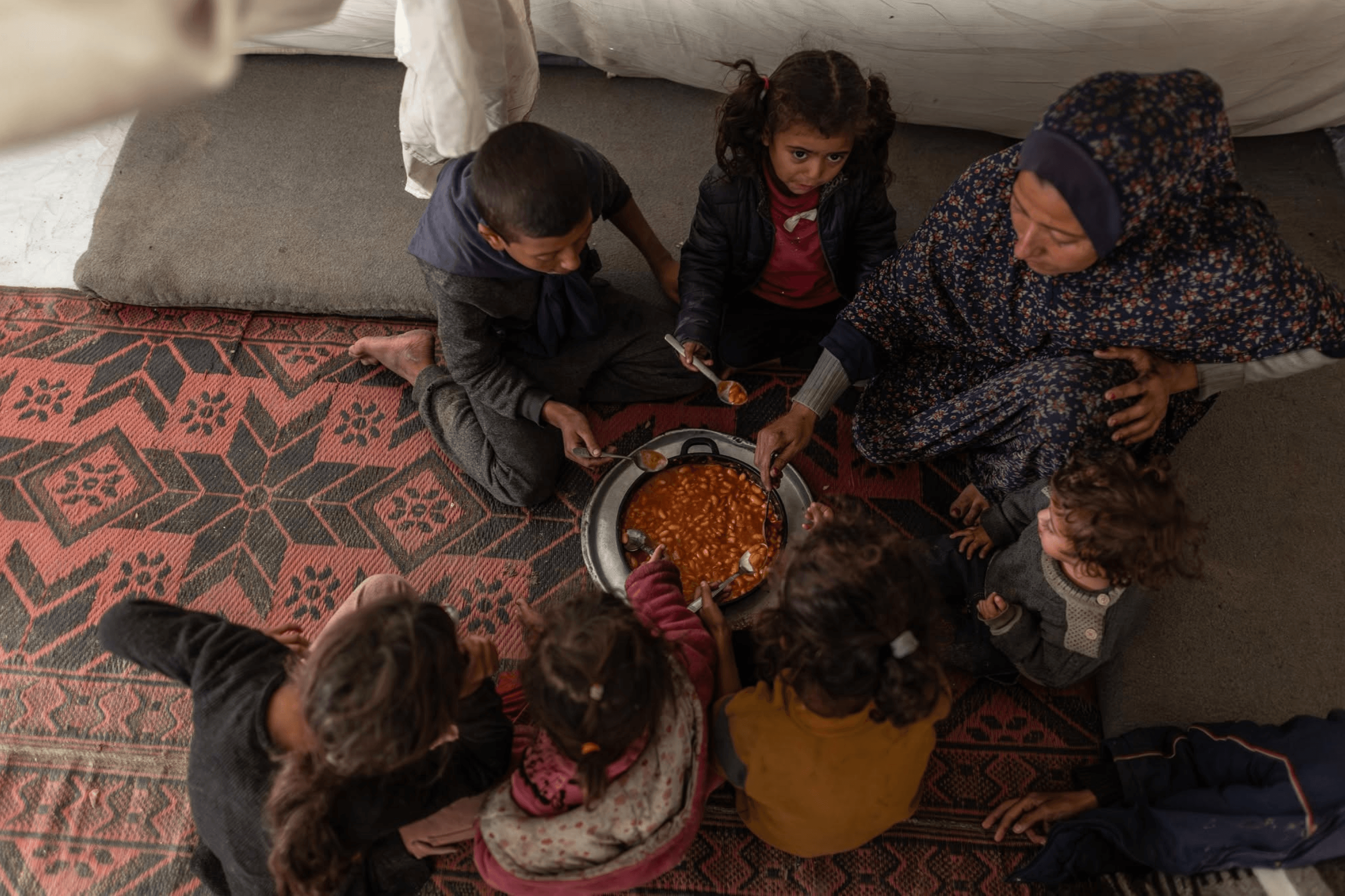 Nimat and her children receive food from World Central Kitchen in Khan Younis, Gaza Strip. January 9, 2026.