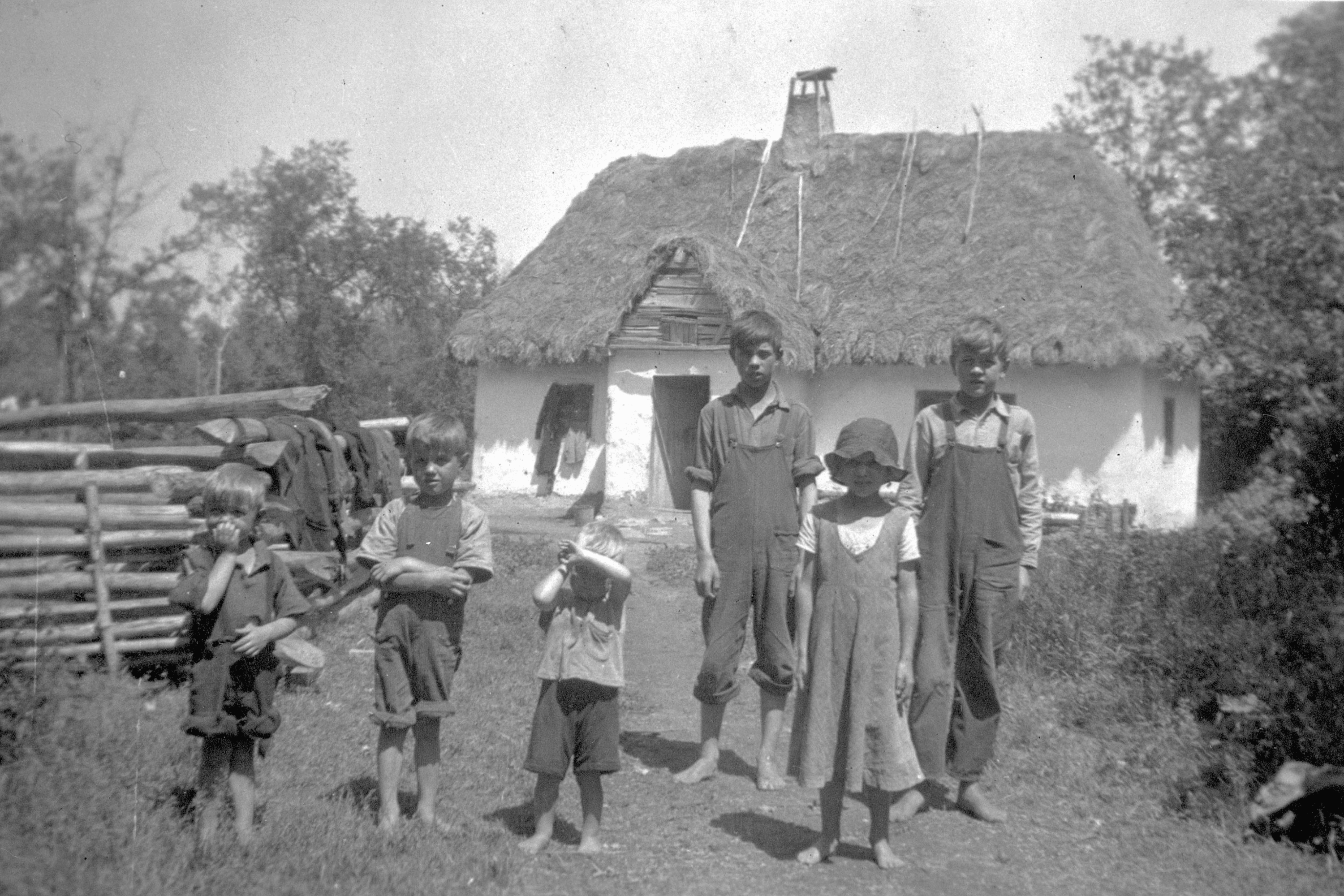 A Ukrainian family outside a Ukrainian-style house in Athabasca, Alberta, Canada. 1920.