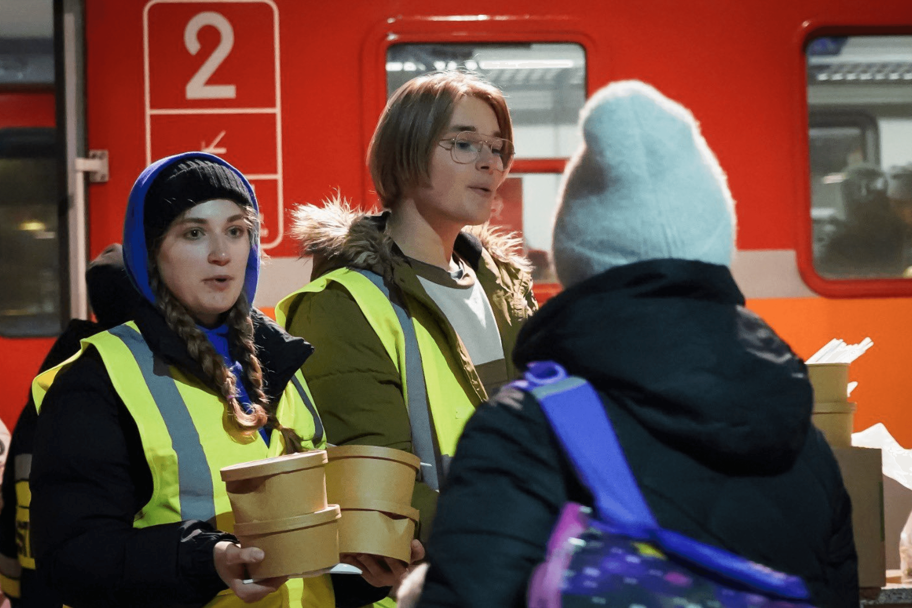 16-year-old twins Gnitecki and Gabrielab help World Central Kitchen distribute food to Ukrainians arriving in Poland. March 2022.