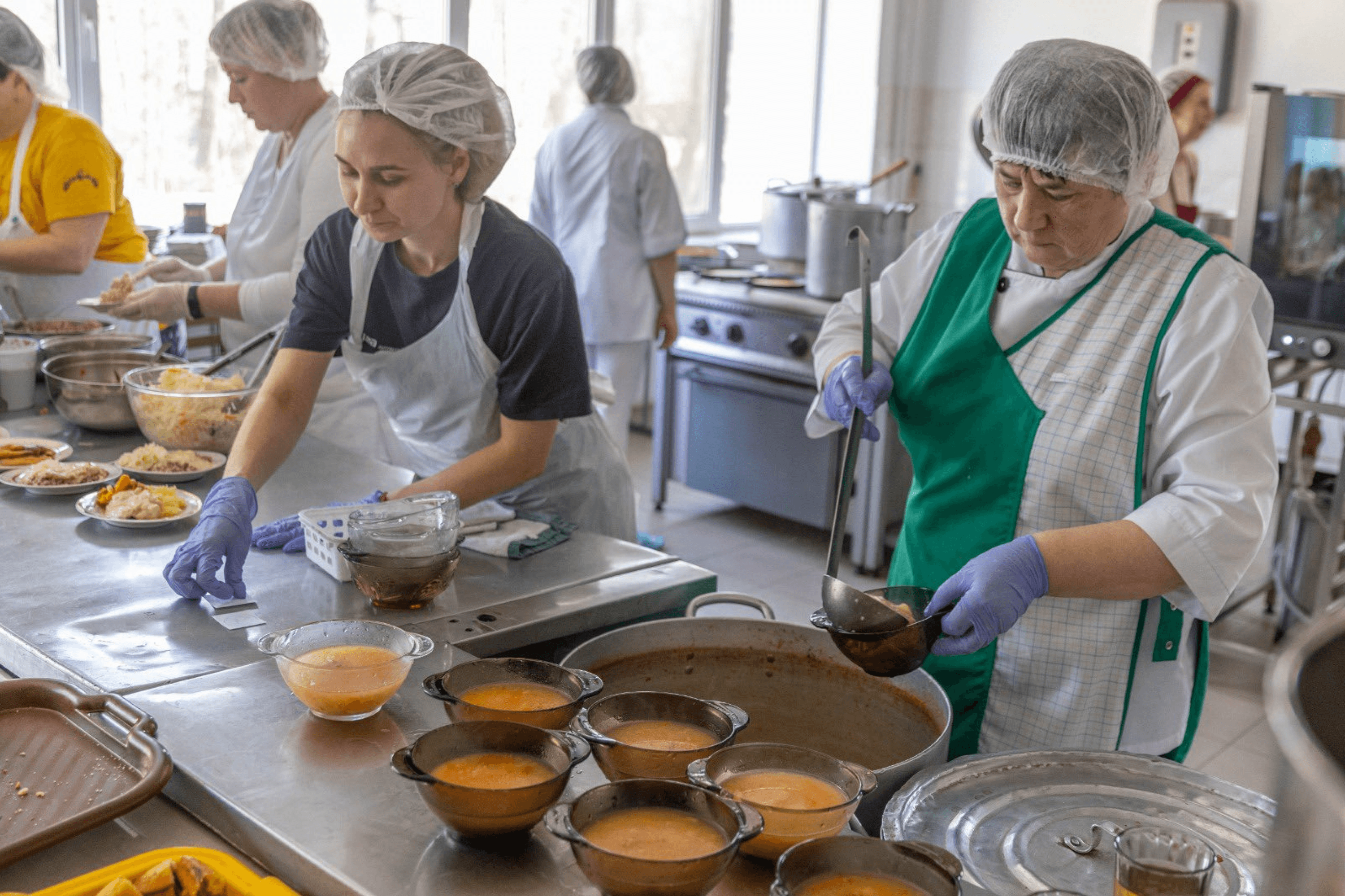 Local residents prepare food for displaced people at one of the kitchens in Morshyn supported by World Central Kitchen. March 2022.