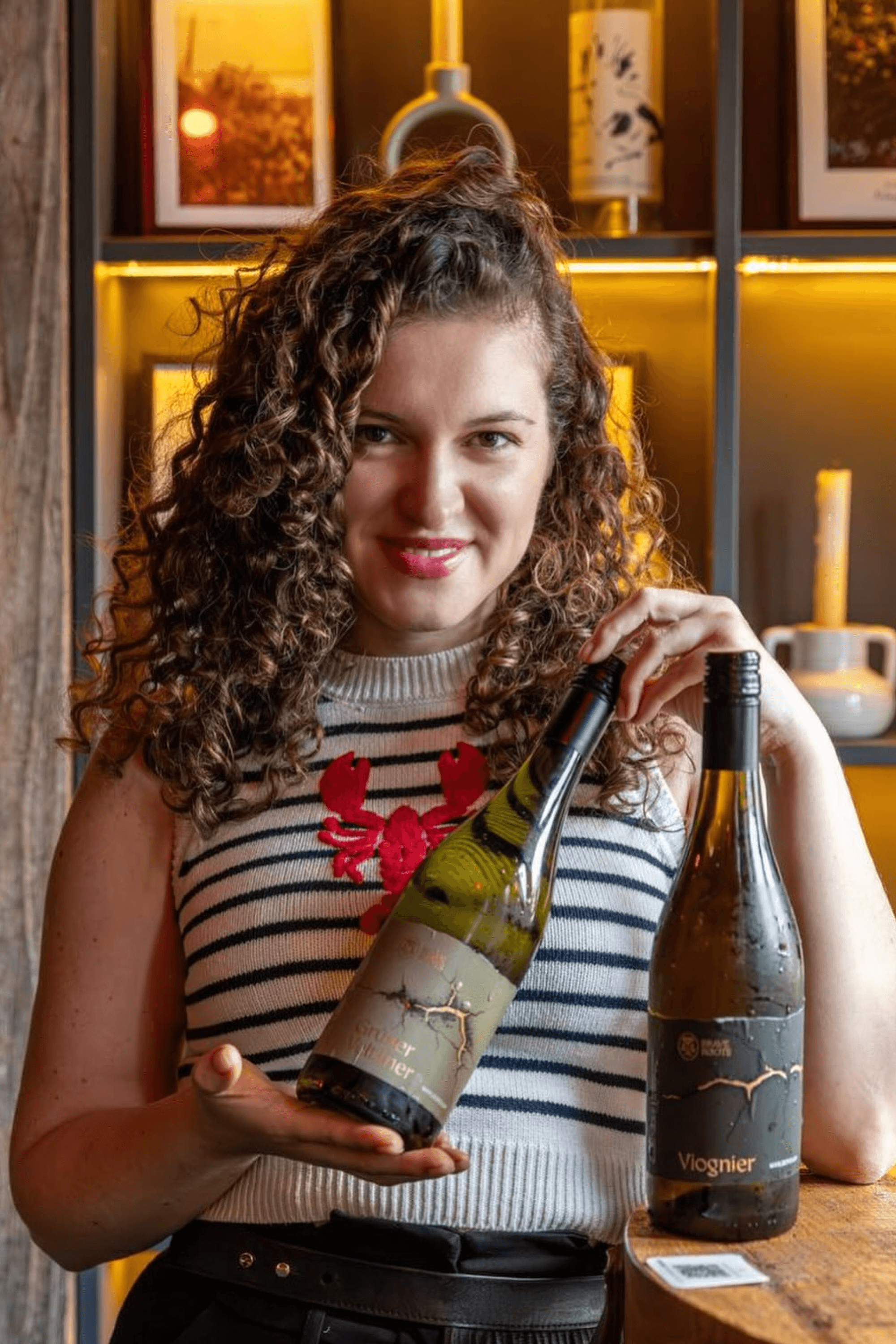 Jenia Nikolaichuk with bottles of Brave Roots wine.
