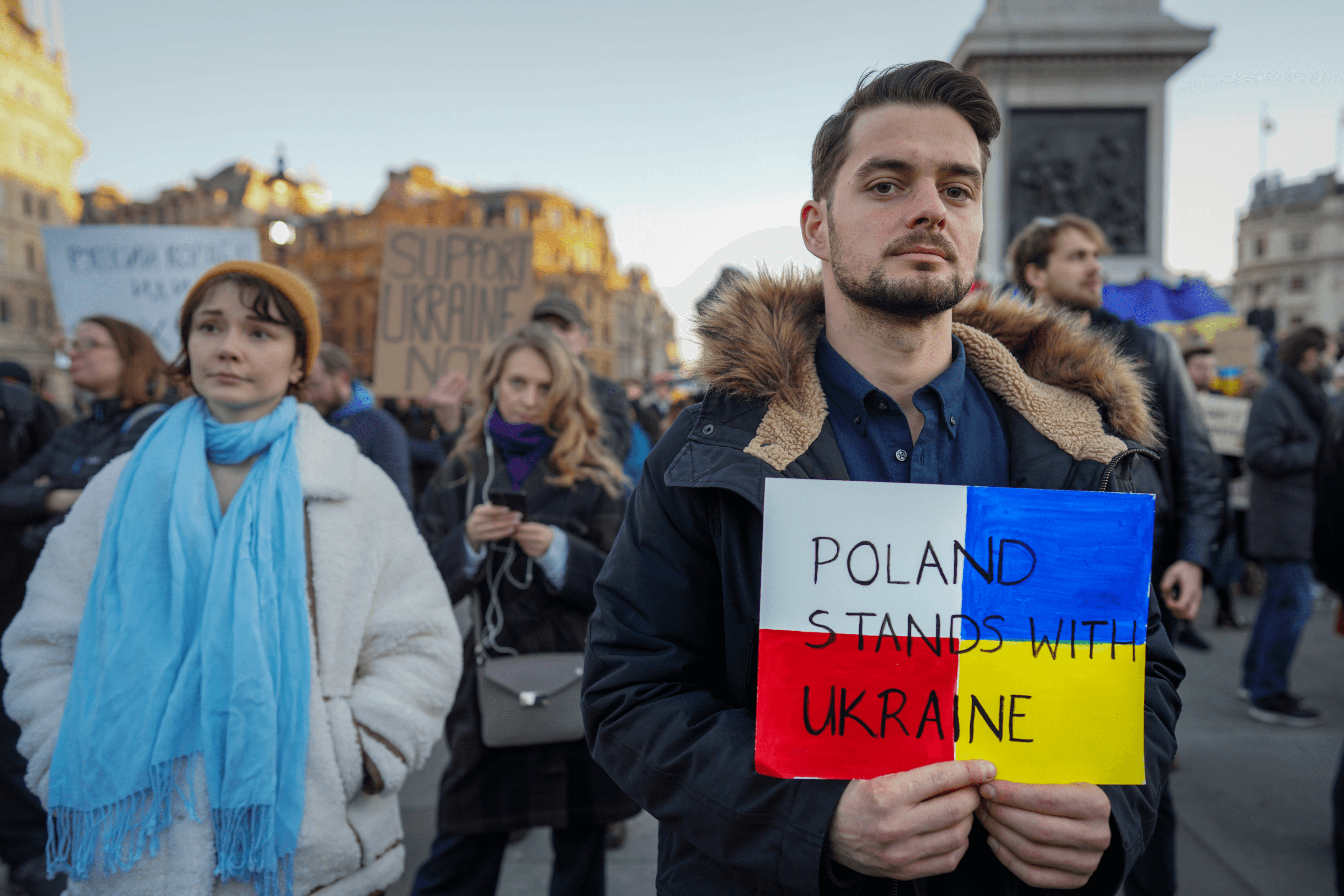 A participant in a pro-Ukraine rally holds a “Poland Stands with Ukraine” sign. London, United Kingdom, February 27, 2022.